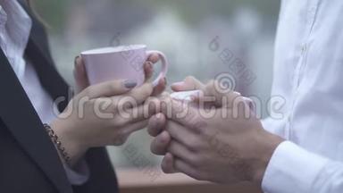 男女双手捧杯咖啡在户外特写镜头男女双手捧杯